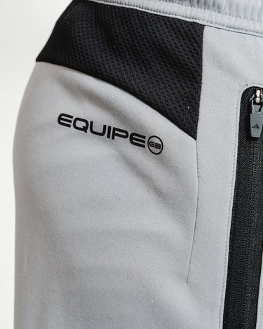 Close-up of EQUIPE GB logo and black mesh waist insert on gray GB Team Track Jogger by adidas.