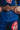 Close-up of blue GB x adidas III Stripes Women’s Kimono during training, showing embroidered Performance text and large Red Shield patch below brown belt.