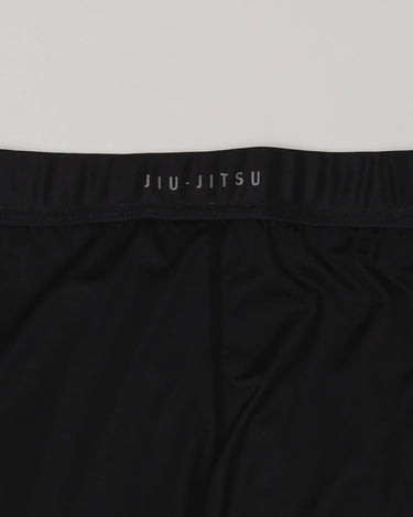 Close-up of the GB x adidas III Stripes Compression Pants waistband showing “JIU-JITSU” branding on black performance fabric.