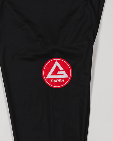 Close-up of the GB x adidas III Stripes Compression Pants showing the Red Shield logo printed on the upper leg of black performance fabric.