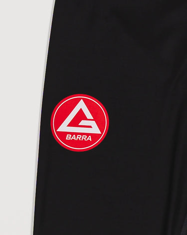 Close-up of the GB x adidas III Stripes Women’s Compression Tights showing the Red Shield logo printed on the upper leg.