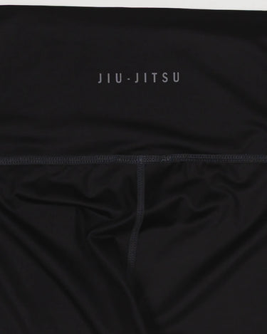 Close-up of the waistband on the GB x adidas III Stripes Women’s Compression Tights showing the “Jiu-Jitsu” text detail on black fabric.