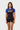 Student wearing the blue III Stripes Womens Ranked Rashguard by adidas, with blue raglan sleeves, three red stripes and gray stacked Gracie Barra logo