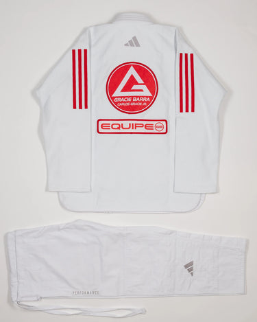 Back view of white GB x adidas III Stripes Women’s Kimono on white background, featuring large Red Shield patch with Gracie Barra lettering, EQUIPE patch below, and GB Red 3-Stripes on sleeves.