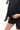 Legacy Womens Active Tee in black, close-up of model lifting the hem to show the lightweight performance fabric and flatlock seam.