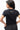 Legacy Womens Active Tee in black, back view on model showing flatlock shoulder seams and Gracie Barra wordmark at upper back.