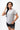 Legacy Womens Active Tee in grey, front view on model with hand to hair, short sleeves and white Legacy G chest logo.