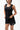 Legacy Womens Performance Racerback Tank in black, front view on model with hands at the hem, scoop neckline and white Legacy G chest logo.