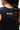 Legacy Womens Performance Racerback Tank in black, back view close-up showing racerback design and stacked Gracie Barra wordmark at upper back.