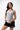 Legacy Womens Performance Racerback Tank in grey, full-length front view on standing model with white Legacy G chest logo.
