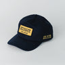 Navy blue Gracie Barra Lutador Cap with gold embroidered patch on front reading “Gracie Barra Jiu-Jitsu” and additional gold “Jiu-Jitsu Brasileiro” text on the side.