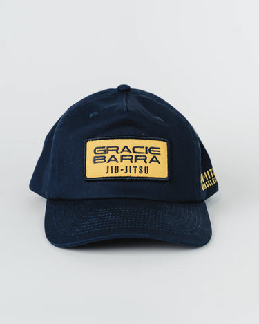 Front view of navy blue Gracie Barra Lutador Cap with gold embroidered patch reading “Gracie Barra Jiu-Jitsu” and gold “Jiu-Jitsu Brasileiro” text on the side.