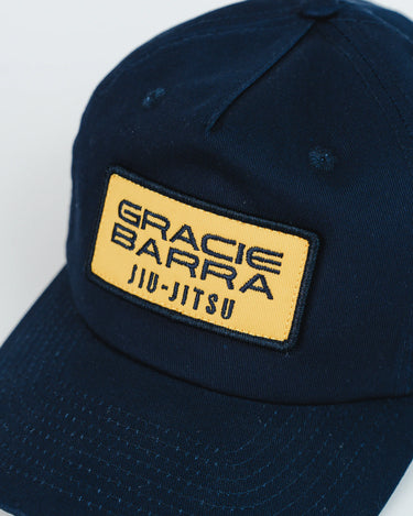 Close-up front view of navy blue Gracie Barra Lutador Cap with gold embroidered patch reading “Gracie Barra Jiu-Jitsu."