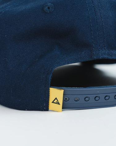 Back close-up of navy blue Gracie Barra Lutador Cap with adjustable snapback closure and yellow Legacy G tag detail.