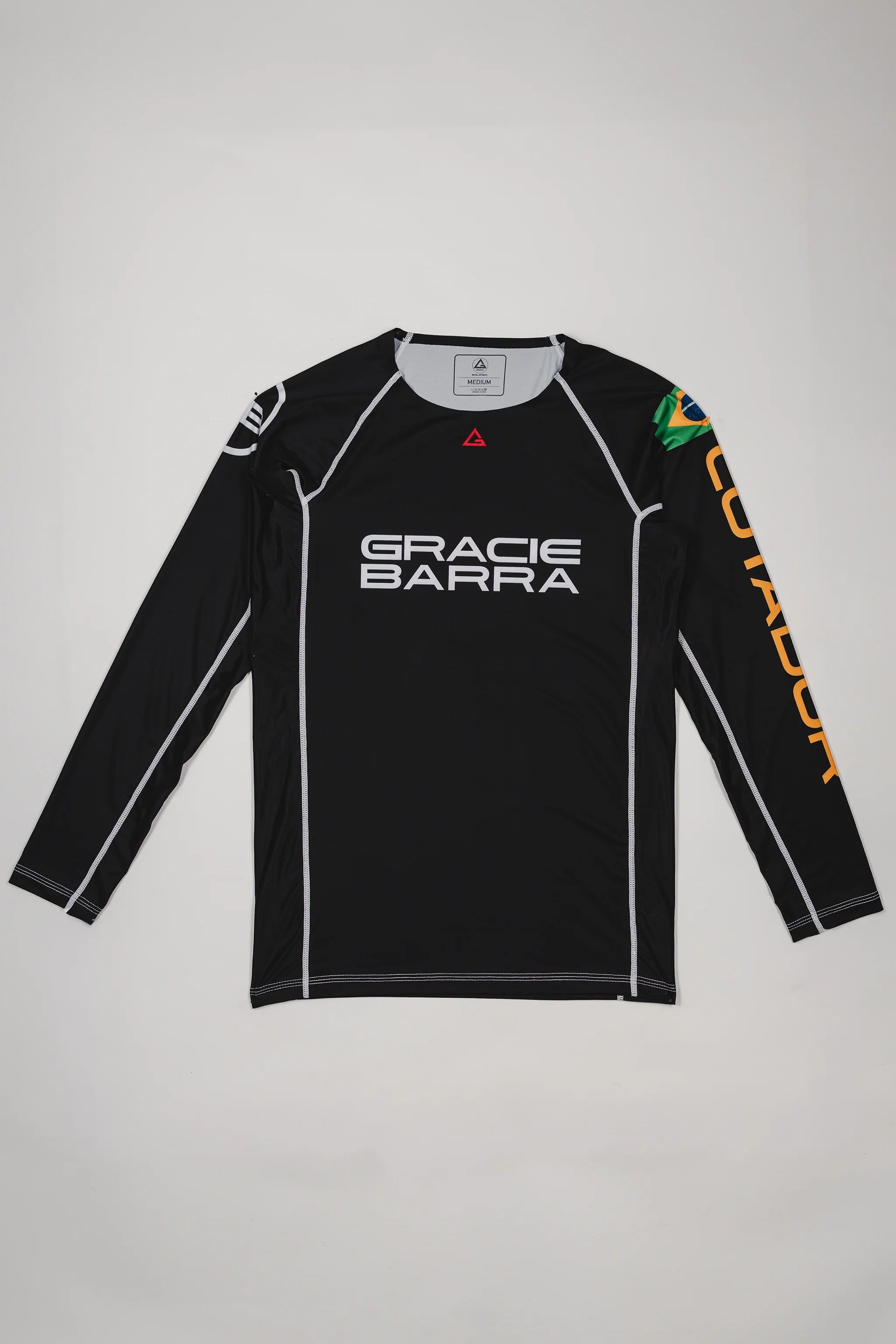 Full front view of the Lutador Longsleeve Ranked Rashguard in black, featuring the black torso, black raglan sleeves, white Gracie Barra wordmark, Brazilian flag arm patch, and gold ‘Lutador’ sleeve print.