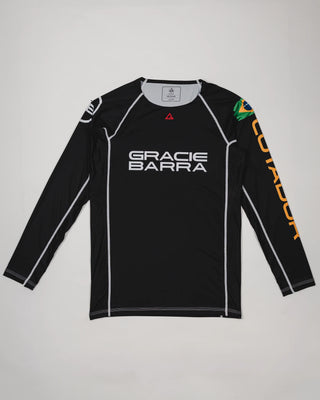 Full front view of the Lutador Longsleeve Ranked Rashguard in black, featuring the black torso, black raglan sleeves, white Gracie Barra wordmark, Brazilian flag arm patch, and gold ‘Lutador’ sleeve print.