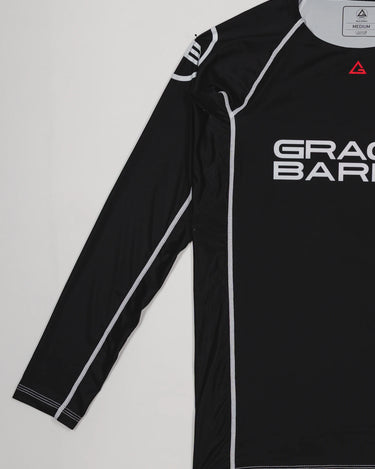 Side view of the black Lutador Longsleeve Ranked Rashguard showing the full black sleeve with white contrast stitching and the Gracie Barra chest logo.