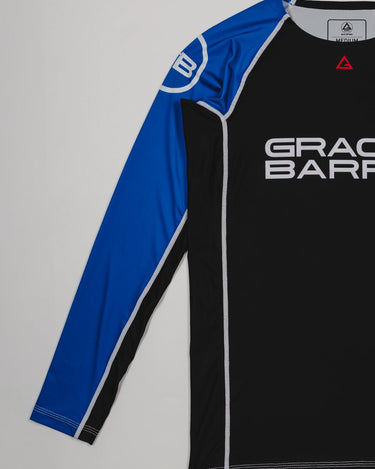 Side view of the Lutador Longsleeve Ranked Rashguard in blue, showing the full blue raglan sleeve with the white GB circle logo and the black torso with Gracie Barra branding.