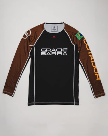 Full front view of the Lutador Longsleeve Ranked Rashguard in brown, featuring the black torso, brown raglan sleeves, Gracie Barra wordmark, Brazilian flag arm patch, and gold ‘Lutador’ sleeve print.