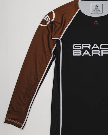 Side view of the Lutador Longsleeve Ranked Rashguard in brown, showing the full brown raglan sleeve with the white GB circle logo and the black torso with Gracie Barra branding.