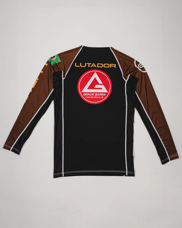 Back view of the Lutador Longsleeve Ranked Rashguard in brown, showing the large red Barra Shield, gold ‘Lutador’ text, Brazilian flag sleeve patch, and brown raglan sleeves.