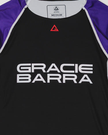 Close-up of the Lutador Longsleeve Ranked Rashguard in purple, showing the black torso, purple raglan sleeves, red Legacy G chest logo, and large white Gracie Barra wordmark.