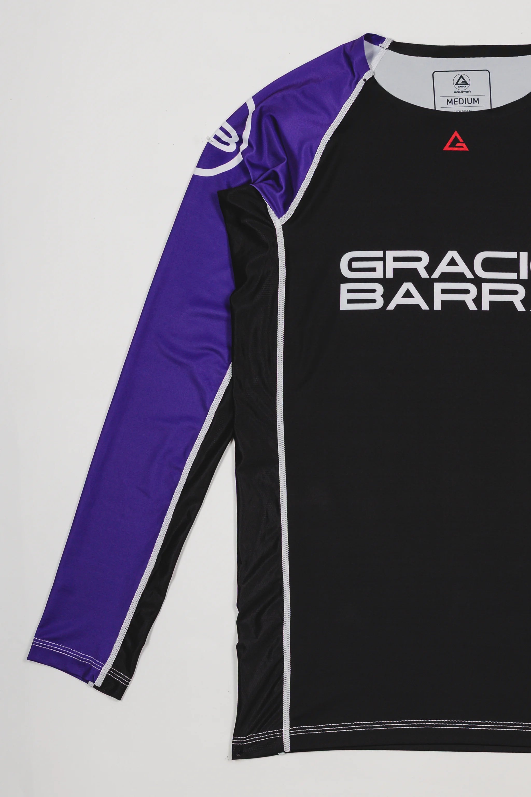 Side view of the Lutador Longsleeve Ranked Rashguard in purple, showing the full purple raglan sleeve with the white GB circle logo and the black torso with Gracie Barra branding.