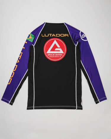 Back view of the Lutador Longsleeve Ranked Rashguard in purple, showing the large red Barra Shield, gold ‘Lutador’ text, Brazilian flag sleeve patch, and purple raglan sleeves.