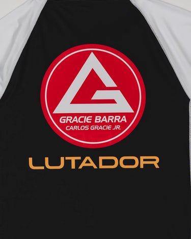Close-up of the back of the Lutador Longsleeve Ranked Rashguard showing the large red Barra Shield and gold ‘Lutador’ text on the black panel with white raglan sleeves.