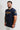 Navy Gracie Barra Lutador mens tee, three-quarter front view with the gold LUTADOR chest print, Equipe GB badge, and gold triangle logo on the sleeve.