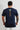 Back of the navy Gracie Barra Lutador mens tee with the Brazilian flag above a vertical gold Jiu-Jitsu print running down the spine.