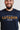 Close-up of the gold LUTADOR chest print with the Gracie Barra line above and the white Equipe GB badge below on the navy Lutador mens tee.