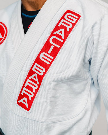 White traditional cut Gracie Barra AtletaGB V4 Kimono with GB patchwork on left chest, showcasing premium cotton durability
