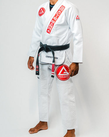 Side view of model in white AtletaGB V4 Jiu-Jitsu Gi, showing prominent chest and leg patches