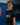 Gracie Barra student smiling on the mat in the black Proximity kids training tee, showing the gray diagonal panel and white Gracie Barra chest print