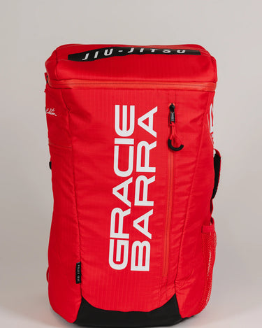 Front view of Red Comp GB4 Backpack featuring bold vertical “Gracie Barra” logo and black “Jiu-Jitsu” patch on top, part of the official Red Comp Collection.