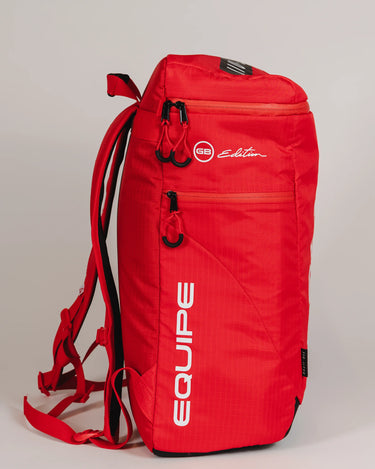 Side view of Red Comp GB4 Backpack from Gracie Barra’s Red Comp Collection showing “Equipe” and “GB Edition” logos with red straps and ventilation pocket.