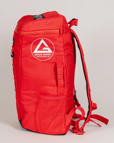 Side profile of Red Comp GB4 Backpack featuring the Gracie Barra shield logo, mesh side pocket, and ergonomic red straps from the official Red Comp Collection.