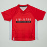 Kids’ Red Comp Team Jersey featuring the official Jiu-Jitsu Competition Team front graphic and tonal Legacy G pattern in signature GB Red on a light background.