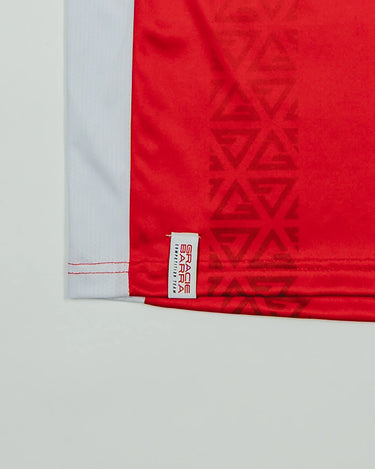 Close-up of the Kids’ Red Comp Team Jersey showing the tonal Legacy G geometric pattern and woven Gracie Barra Competition Team label above the hem.
