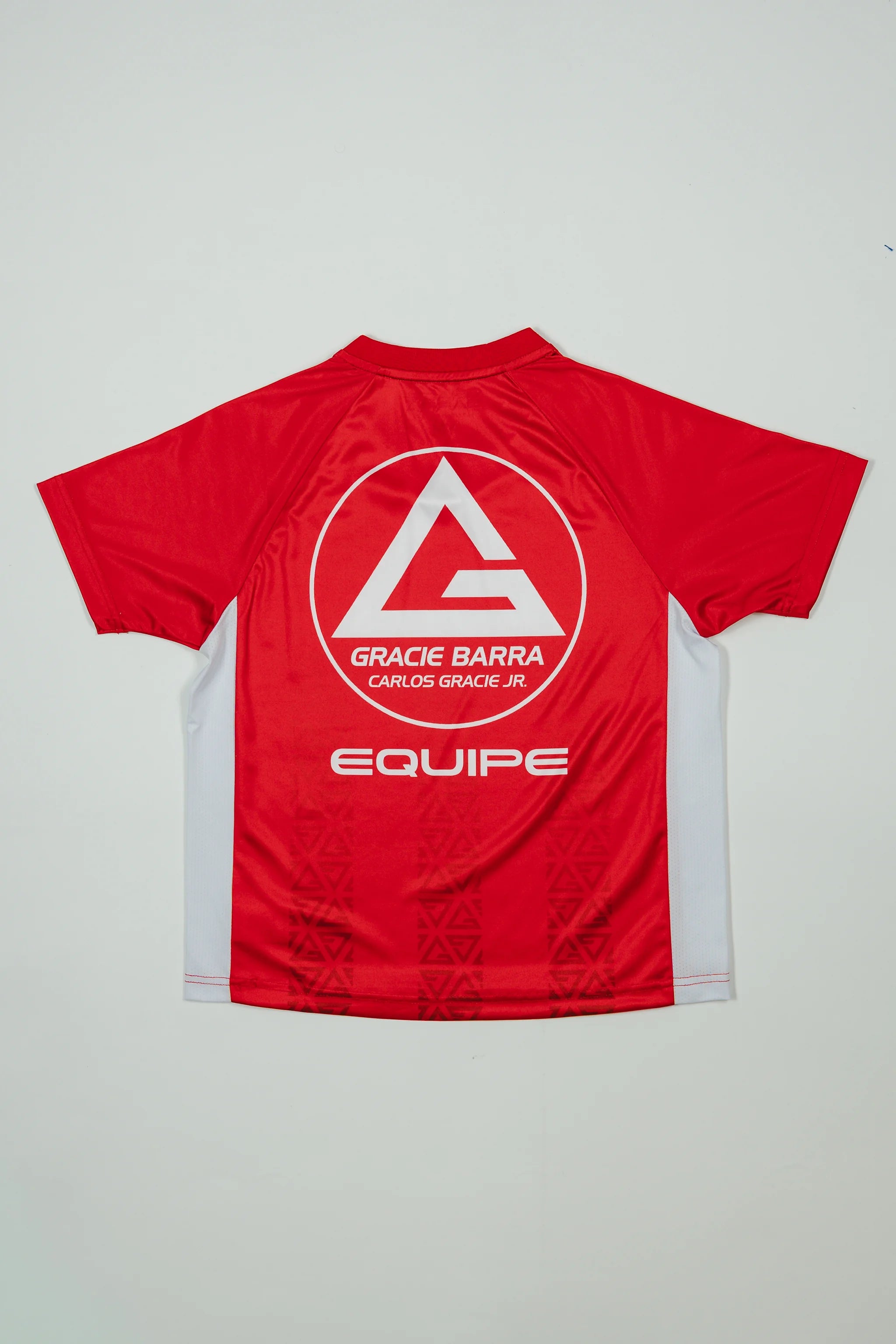 Back view of the Kids’ Red Comp Team Jersey showing the Red Shield logo, “Equipe” graphic, and tonal Legacy G pattern on a light background.