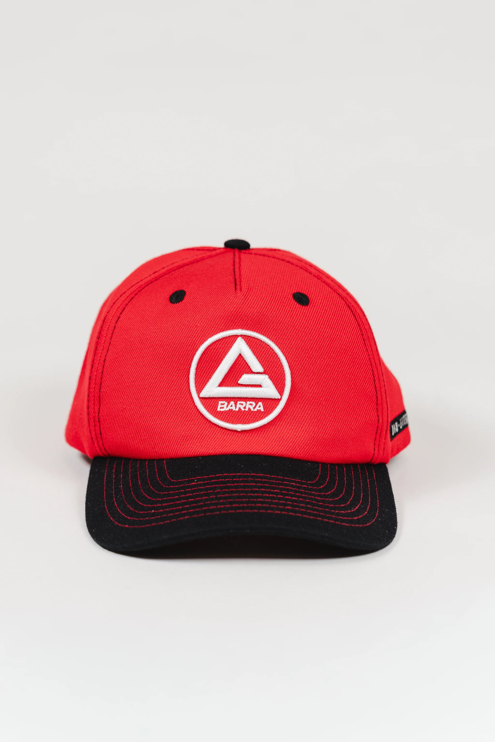 Front view of red GB Red Comp Team Cap featuring the embroidered Red Shield logo on the crown and a black brim with red stitching, shown on a light background.
