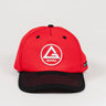 Front view of red GB Red Comp Team Cap featuring the embroidered Red Shield logo on the crown and a black brim with red stitching, shown on a light background.