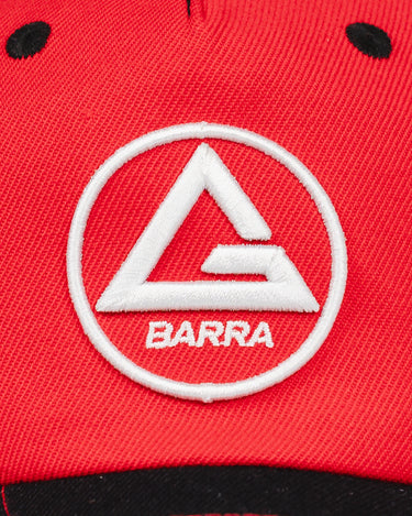 Close-up of the Red Comp Team Cap showing raised white embroidery of the Red Shield logo on GB Red twill fabric above a black brim.