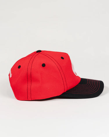 Side profile of the Red Comp Team Cap showing the structured red wool twill panels, black brim with red stitching, and black eyelets.
