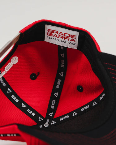 Close-up of the Red Comp Team Cap interior showing the Gracie Barra Competition Team woven label and inner taping with Legacy G and Jiu-Jitsu graphics.