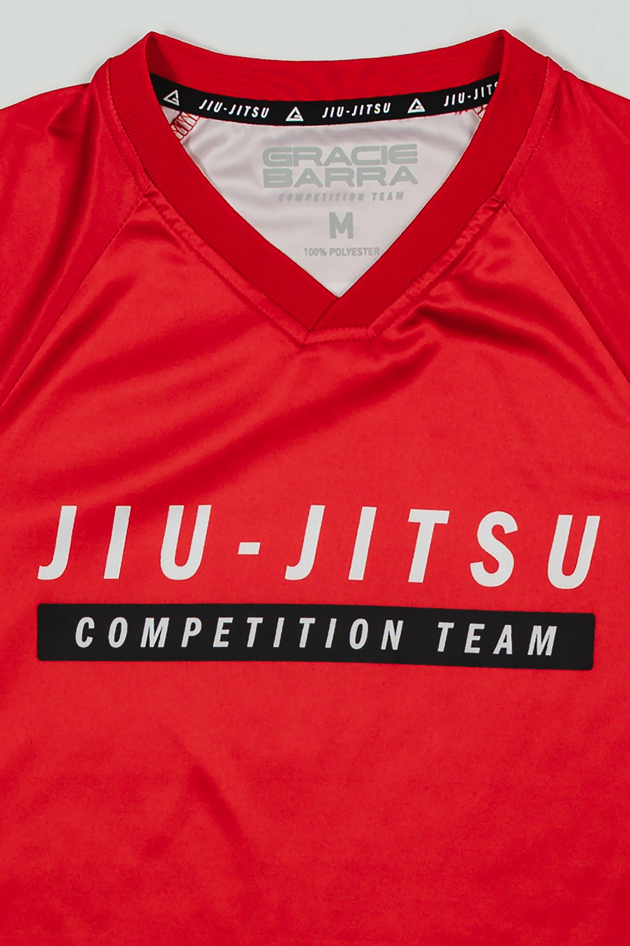 Close-up of Red Comp Women’s Team Jersey showing the official “Jiu-Jitsu Competition Team” graphic and Gracie Barra neck label on GB Red fabric.
