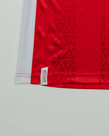 Close-up of Red Comp Women’s Team Jersey showing tonal GB Red pattern and woven Gracie Barra stacked logo label above the hem.