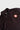 Close-up of the rubberized red Barra Shield logo, collar and three-button placket on the black Red Shield Terra Mar polo