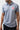 Upper body front of the gray Red Shield Terra Mar polo showing the classic collar, three-button placket and rubberized red Barra Shield on the chest.